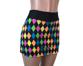 May include: A black mini skirt with a colorful diamond pattern. The skirt has a black waistband and is made of a stretchy fabric. The colors in the pattern are neon pink, green, yellow, blue, and orange.