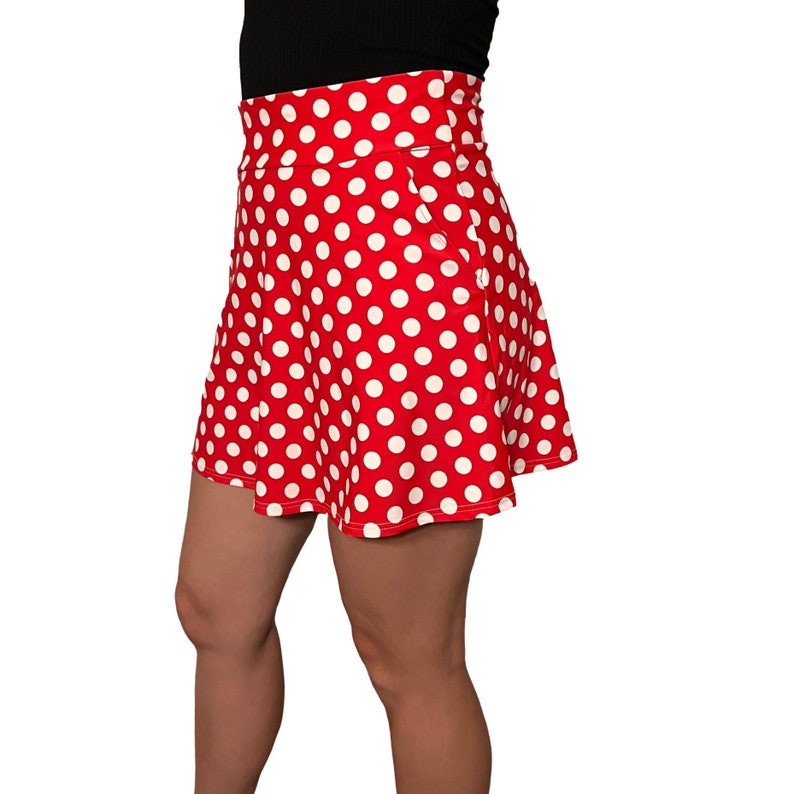 May include: A red skirt with white polka dots. The skirt has a high waist and a flared silhouette.