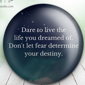 May include: A blue and green orb with white stars and a white text overlay that reads "Dare to live the life you dreamed of. Don't let fear determine your destiny."