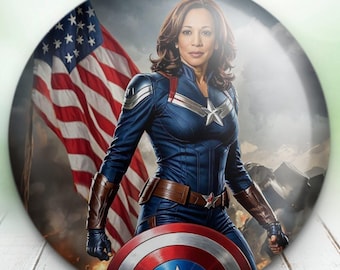 May include: A round button featuring a woman dressed as Captain America, standing in front of an American flag. The woman is wearing a blue and red costume with a star on her chest. She is holding a shield with a red, white, and blue star.