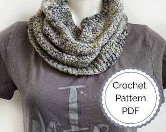May include: A gray and green crochet infinity scarf with a crocheted pattern. The scarf is on a gray t-shirt with the text "I Make" printed on it. The image also includes a gray circle with the text "Crochet Pattern PDF".