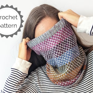 May include: A colorful crochet cowl with a textured stitch pattern. The cowl is made in shades of pink, purple, blue, green, and orange.