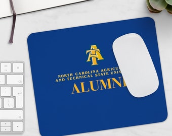 Può includere: Tappetino per mouse blu con un logo dorato che dice "North Carolina Agricultural and Technical State University Alumni".