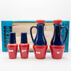 Könnte beinhalten: Ein Satz von vier blauen und roten Salz- und Pfefferstreuern aus Keramik. Die Streuer sind mit "S", "P", "O" und "V" beschriftet. Die Streuer befinden sich in einer blauen und weißen Schachtel mit der Aufschrift "Lastess Oil & Pepper Shakers" auf der Seite.