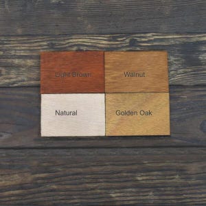 May include: Four wood samples stained in different colours: light brown, walnut, natural, and golden oak.