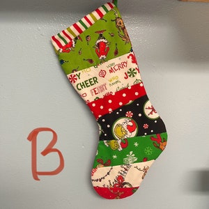 May include: A Christmas stocking with a patchwork design. The stocking features various fabrics with holiday-themed patterns, including the Grinch, snowflakes, and festive text. The top has red and white stripes, and it hangs from a green loop.