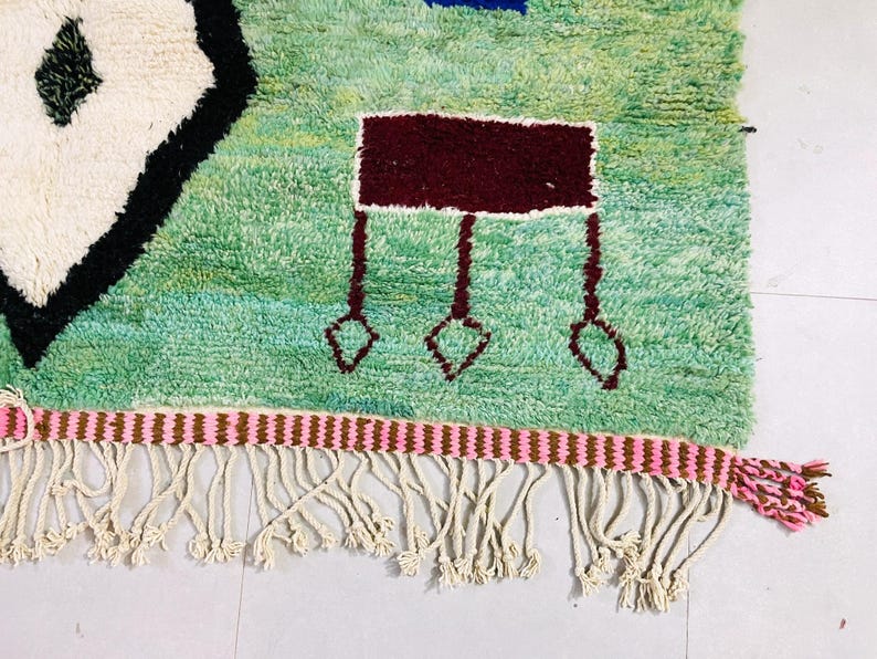 Green wool area rug featuring bold, colorful accents.