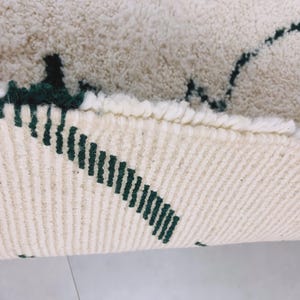 Texture close-up of white Beni Ourain rug showing black pattern details and natural wool fiber variations