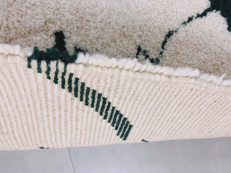 Texture close-up of white Beni Ourain rug showing black pattern details and natural wool fiber variations