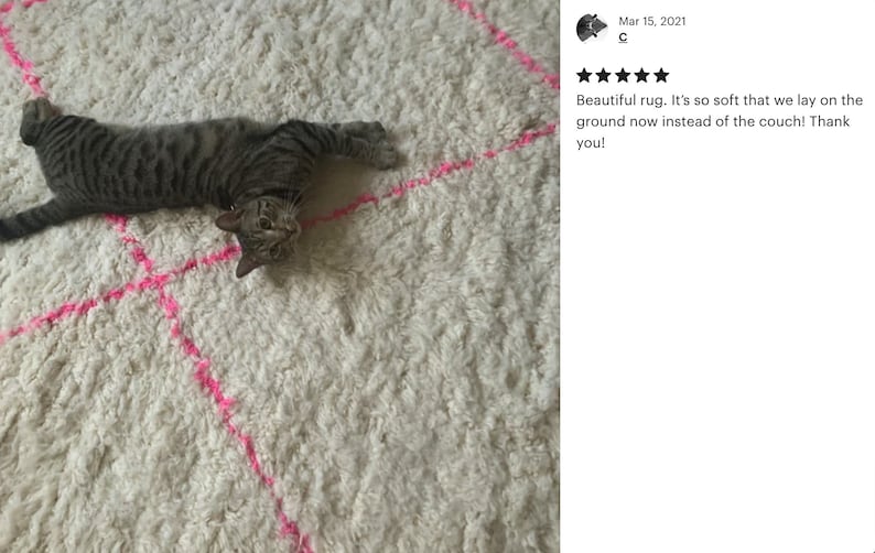 A 5 star review from a happy custom with a picture featuring a Pink and white Beni ourain rug with a cat laying on it