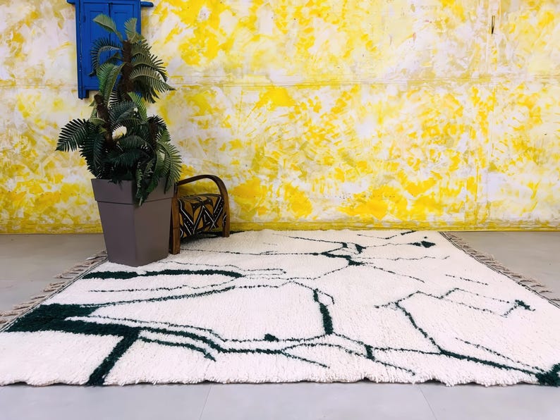 Overhead view of white Beni Ourain rug with black abstract line design on bright yellow backdrop