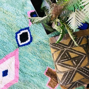 Unique artisan Berber rug with pink, blue, and brown details.