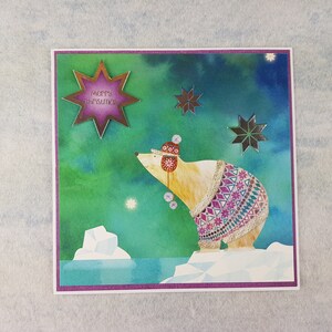 Merry Christmas card with polar bear in a jumper on the card .