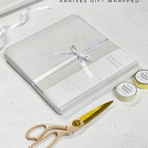 Gift wrapped bridal book in white tissue paper and branded AIM Studio Co ribbon as gift from bridesmaids