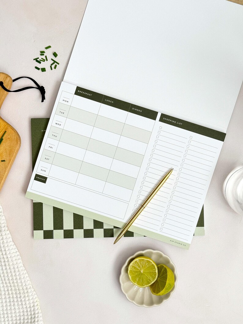 inside page of week view menu planner showing space for breakfast, lunch, dinner and healthy snacks. The page also shows a large shopping list section which has a perforated line to tear-off.