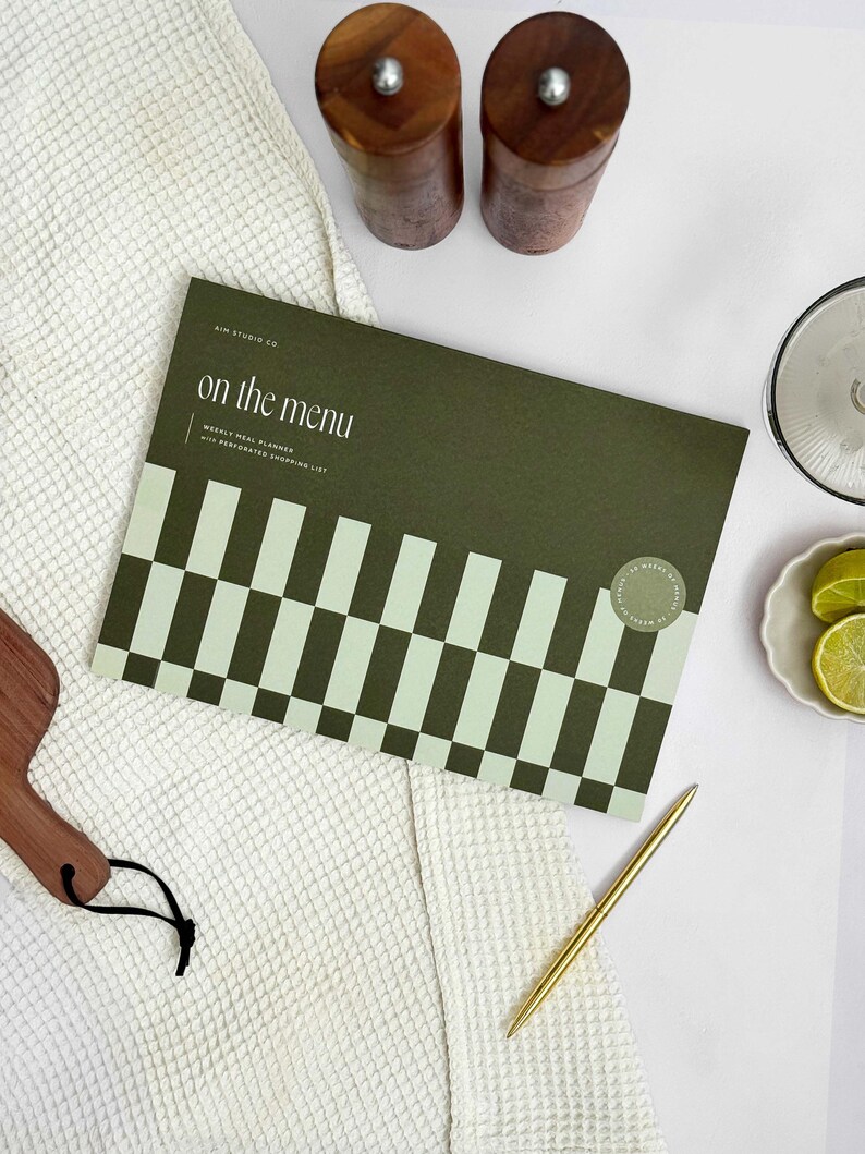 cover of perforated planner  pad for A4 weekly meal planning and writing shopping list. The cover is green with bold, geometric design.