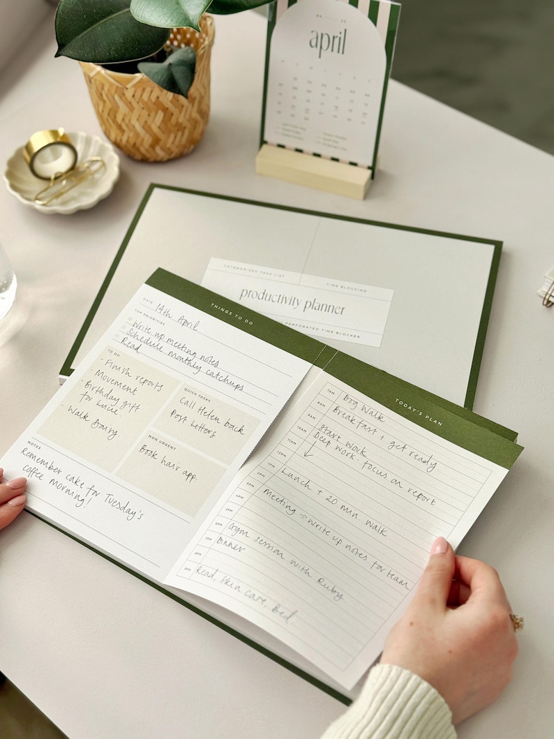 woman at office desk using daily task planner for productivity with time blocking pad for appointments and daily schedule
