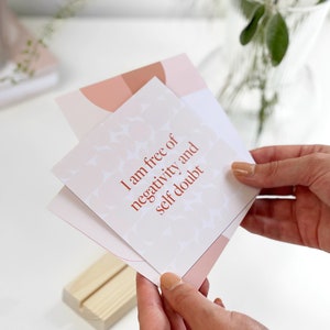 a woman holding a desk of affirmation cards