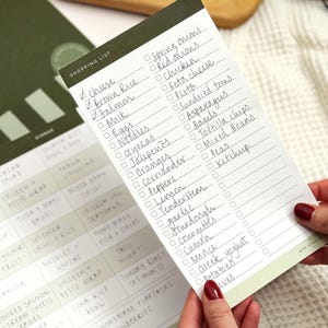 shopping list with list of ingredients with perforation torn off to remove it from the menu planner notepad.