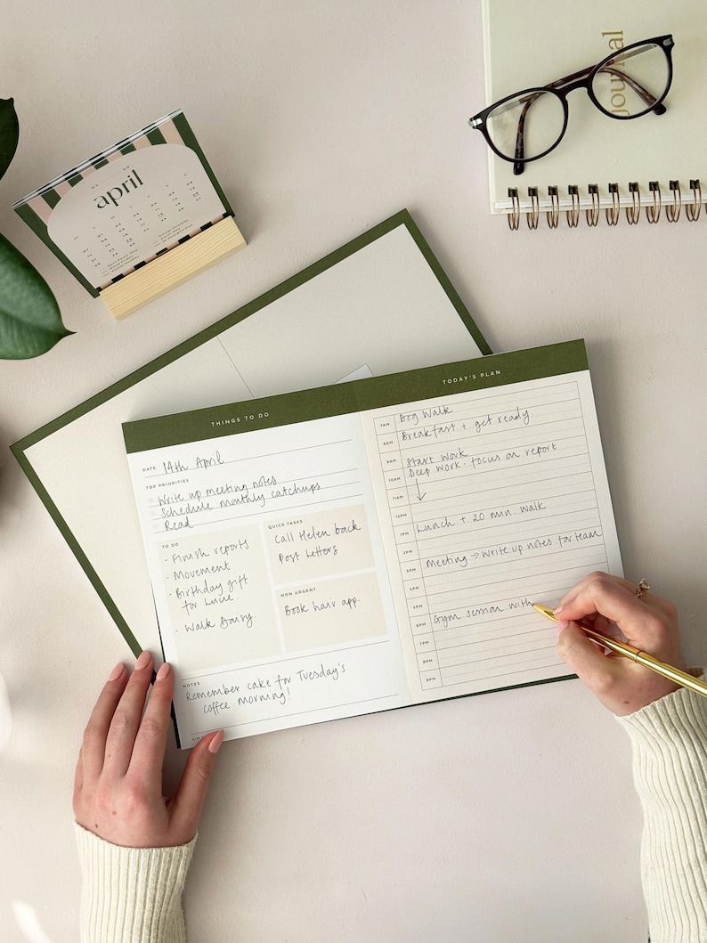 woman at office desk using a4 productivity planner for writing daily schedule and Time blocking tasks