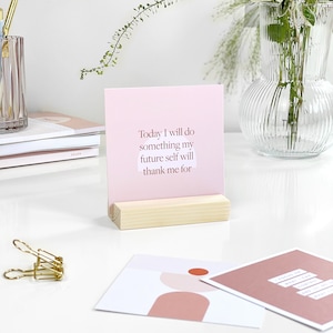 a pink card displaying inspirational quote on an office desk