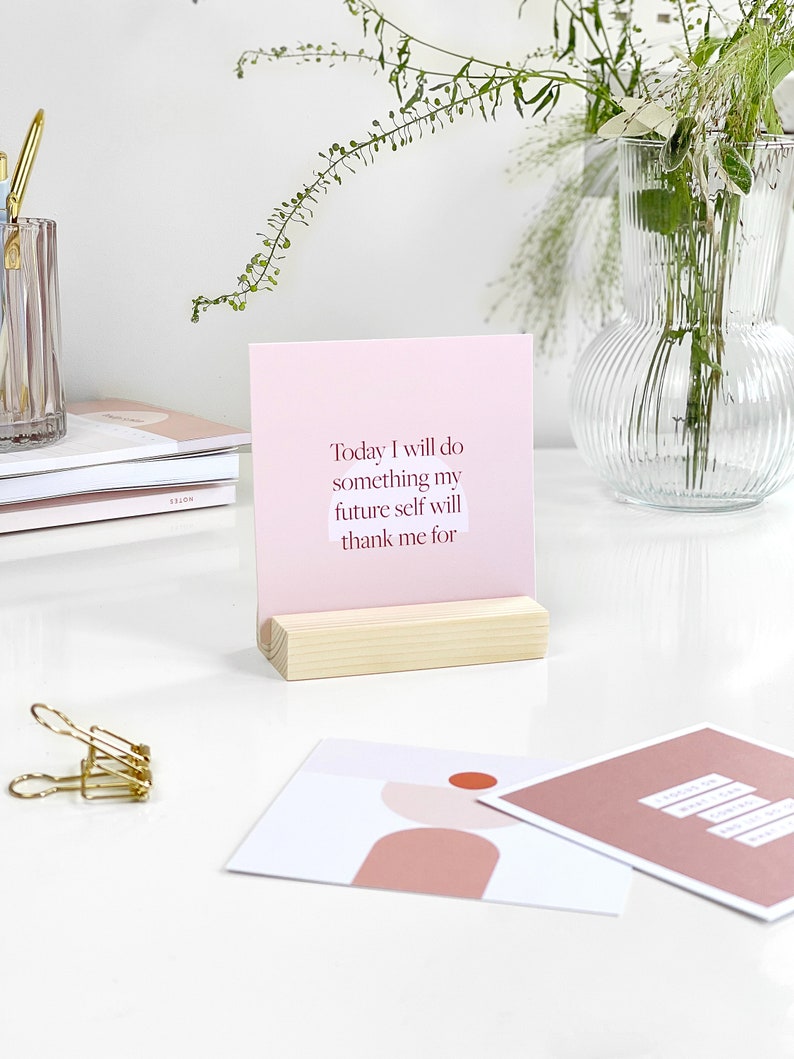 a pink card displaying inspirational quote on an office desk