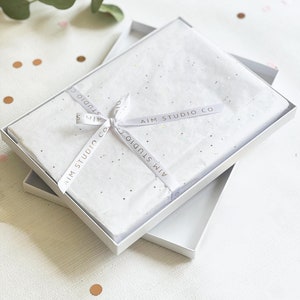 gift boxed coasters in white tissue wrap as a couples gift for valentines day or wedding present for newlywed mr and mrs