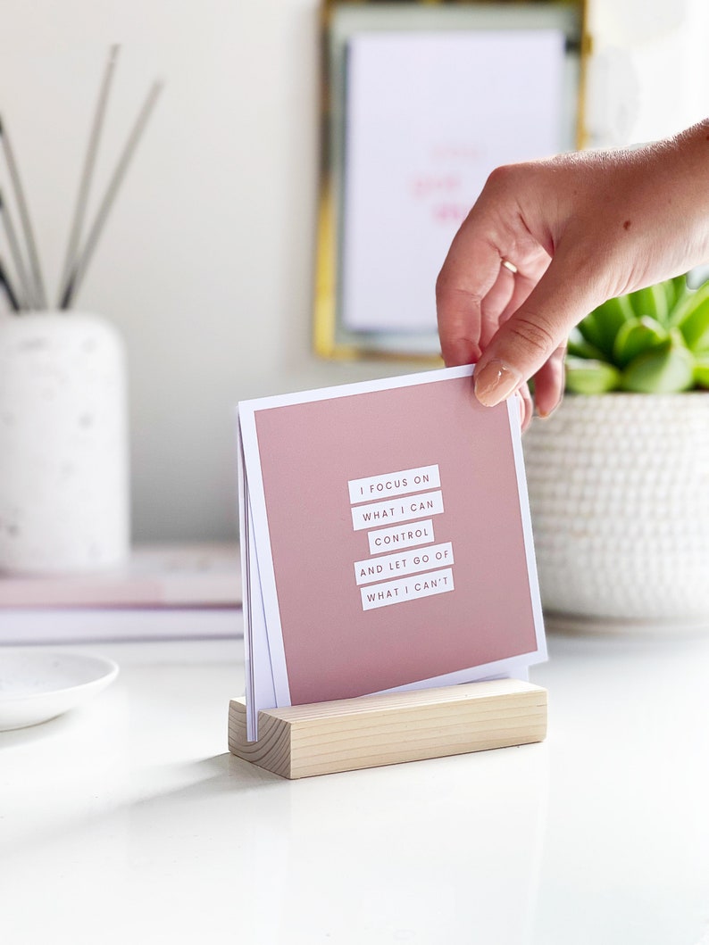 a woman choosing a positive affirmation card to display on her office desk