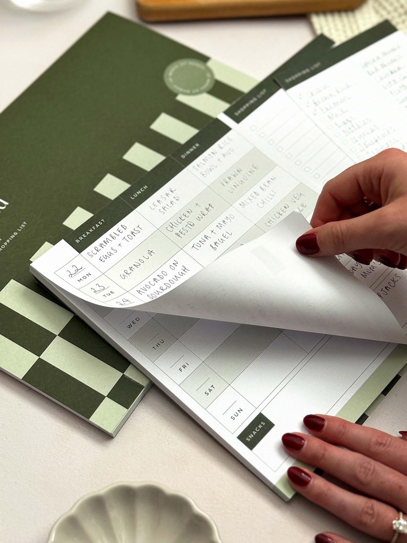 woman removing tear off notepad page from a menu plan notepad