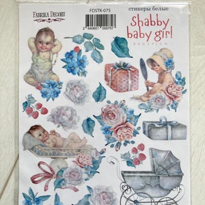 May include: White sticker sheet with a baby girl theme. The sheet includes images of a baby in a crib, a baby in a stroller, a baby holding a mirror, a gift box, flowers, and berries. The text "Shabby baby girl" is printed on the sheet.