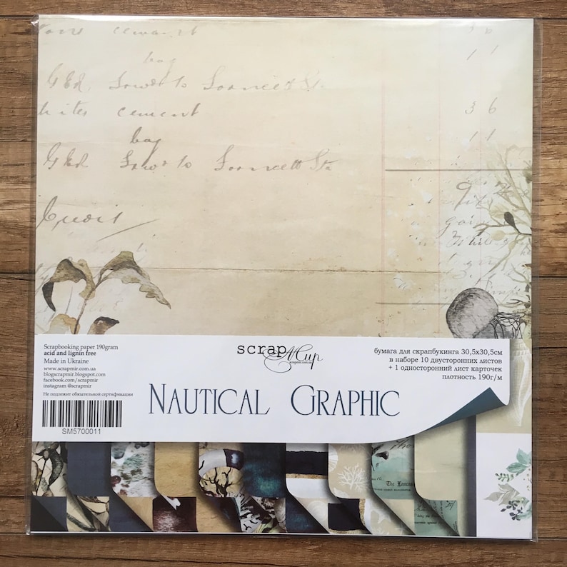 May include: A pack of 10 double-sided scrapbook paper sheets and 1 single-sided cardstock sheet. The paper is 30.5 x 30.5 cm and has a nautical theme with a graphic design. The paper is acid and lignin free and made in Ukraine. The pack is labelled "Scrap Cup Nautical Graphic".