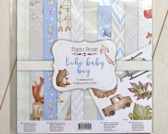May include: A pack of 10 double-sided scrapbook paper sheets with a boho baby boy theme. The paper features a variety of patterns and illustrations, including a bear, a fox, a helicopter, a truck, and a tent. The paper is 8 inches by 8 inches and is made in Ukraine. The pack is labeled "Fabrika Decoru Boho Baby Boy".
