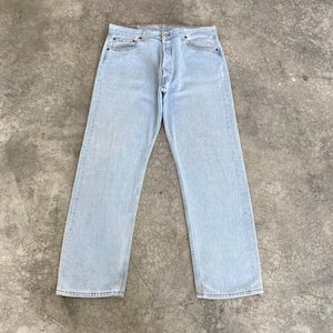May include: Pale blue denim jeans with a button fly and five-pocket design. The jeans have a straight leg fit and are made of a light wash denim material. The jeans are a casual style.