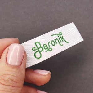 May include: White fabric label with green embroidered text that reads "Baronik".