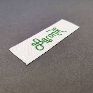 May include: White woven fabric label with the text "Organic" in green embroidery.