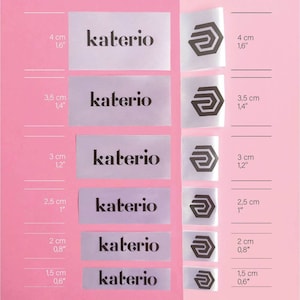 May include: Six white satin labels with the text "katerio" in black lettering and a black logo of a stylized letter "G" in a hexagon. The labels are arranged in a column from largest to smallest, with measurements in inches and centimeters listed next to each label.