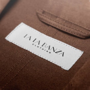 May include: A white label with black text that reads "LALA BANZA CLOTHING" sewn onto a brown fabric.