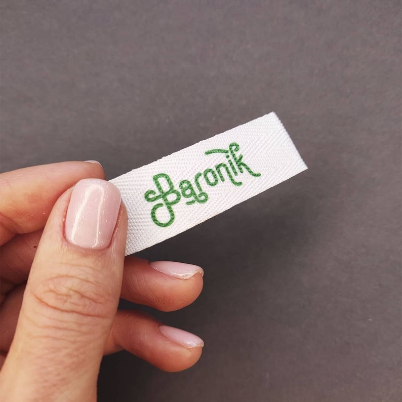 May include: White fabric label with green embroidered text that reads "Baronik".