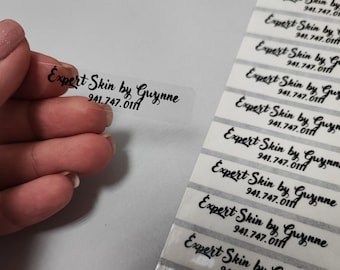 May include: A sheet of clear labels with the text "Expert Skin by Guynne 941.747.011" printed in black cursive font.