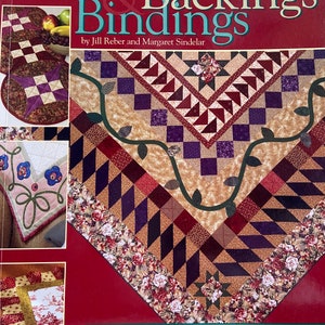 May include: A book titled "Beautiful Borders & Backings Bindings" by Jill Reber and Margaret Sindelar. The book cover features a quilt with a star design and a floral border. The book is a step-by-step guide to 38 finishing techniques, 6 classic borders, 10 easy projects, and 15 galleries.