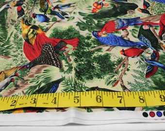 May include: A colorful fabric with a tropical bird pattern. The fabric features a variety of birds, including parrots, toucans, and hummingbirds, in shades of red, blue, green, and yellow. The fabric is printed on a cream-colored background and has a measuring tape placed on top of it, showing measurements in inches.