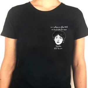 May include: Black t-shirt with a white graphic of a woman's face and the text "oui quelqu'un plus tard se souviendra de nous" and "Sappho 600 av. J.-C."