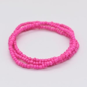 Puede incluir: Un brazalete de cuentas rosa hecho de peque&ntilde;as cuentas redondas. El brazalete est&aacute; envuelto alrededor de s&iacute; mismo varias veces, creando un aspecto grueso y en capas.