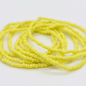 May include: A yellow beaded waist beads, also known as waist beads or belly beads, are a string of beads worn around the waist.