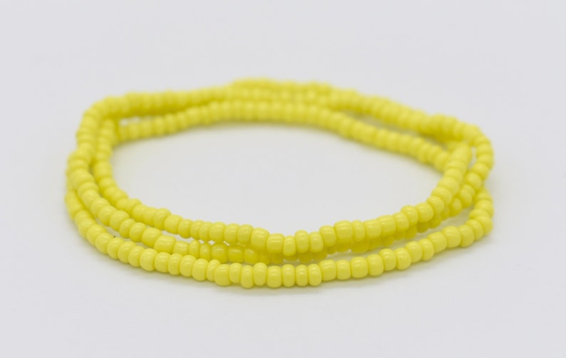 May include: A yellow beaded bracelet with multiple strands of beads.