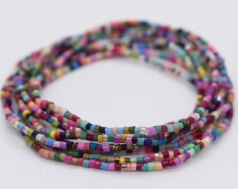 May include: A multi-colored beaded bracelet with a variety of colors, including pink, blue, green, yellow, and purple.