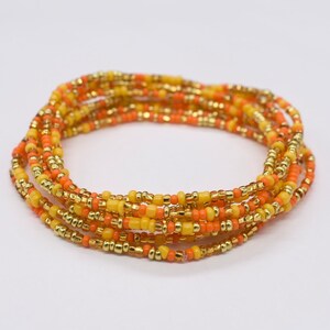 May include: A multi-strand beaded bracelet with gold, yellow, and orange beads.