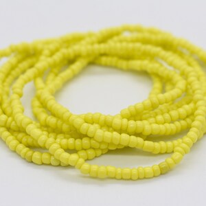 May include: A long strand of bright yellow beads, perfect for making jewelry or adding a pop of color to your crafts.