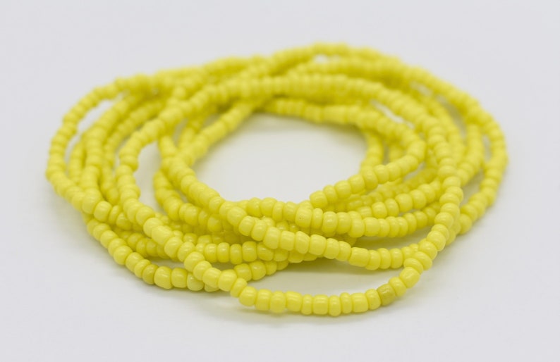 May include: A long strand of bright yellow beads, perfect for making jewelry or adding a pop of color to your crafts.