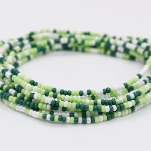 May include: A green, white, and light green beaded bracelet. The bracelet is made of small, round beads and is wrapped around itself several times.